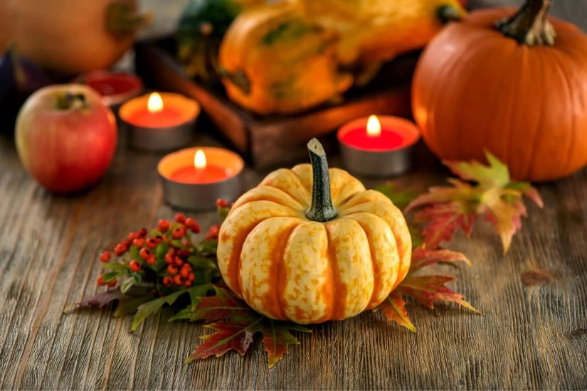 Jesenji aranžman od bundeva i mirišljavih sveća.