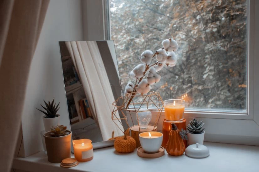 Jesenji dekorativni predmeti pored prozora.